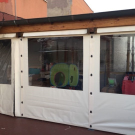 Struttura in legno con chiusura in PVC e inserti in Cristal trasparente. Realizzata in un giardino a Ostia (Roma). Struttura apribile in pochi minuti, ideale come spazio esterno coperto e contenitivo.